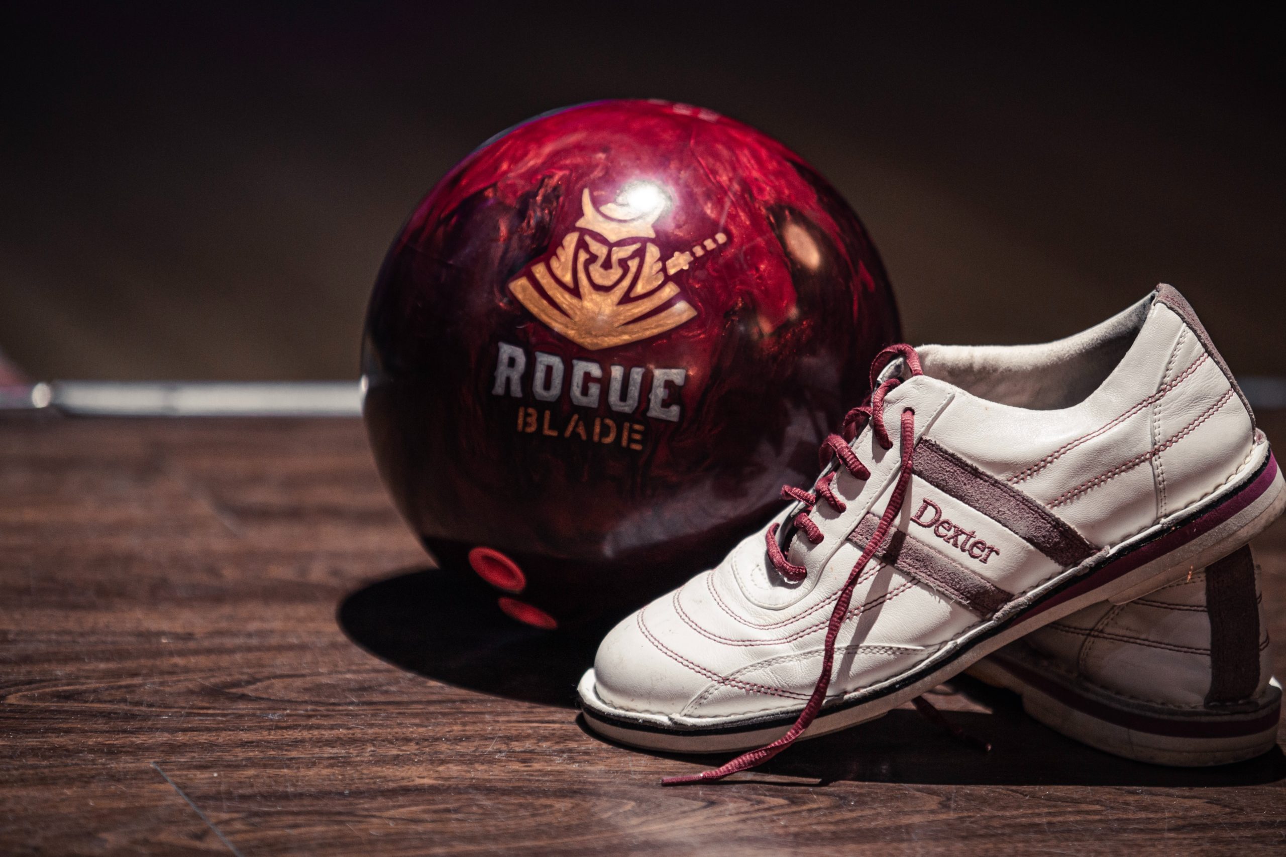 A bowling shoe sits propped up in front of a bowling ball